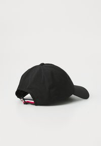 Black baseball cap with a curved brim, made of textured fabric. Features a striped adjustable strap at the back and small ventilation holes.
