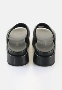 Svarta plattformsandaler med en texturerad, glittrig rem, en mjuk sula och gummisulor. Har en rund form och en minimalistisk design.