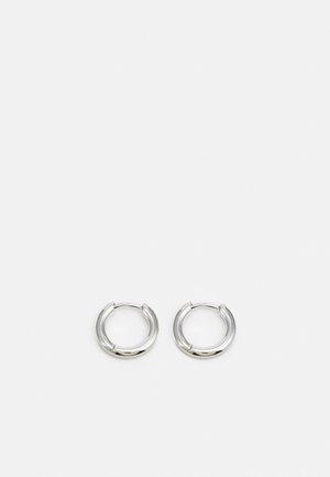 Para małych, gładkich, srebrnych kolczyków kołeczkowych z prostym zapięciem, przedstawionych na jednolitym białym tle.