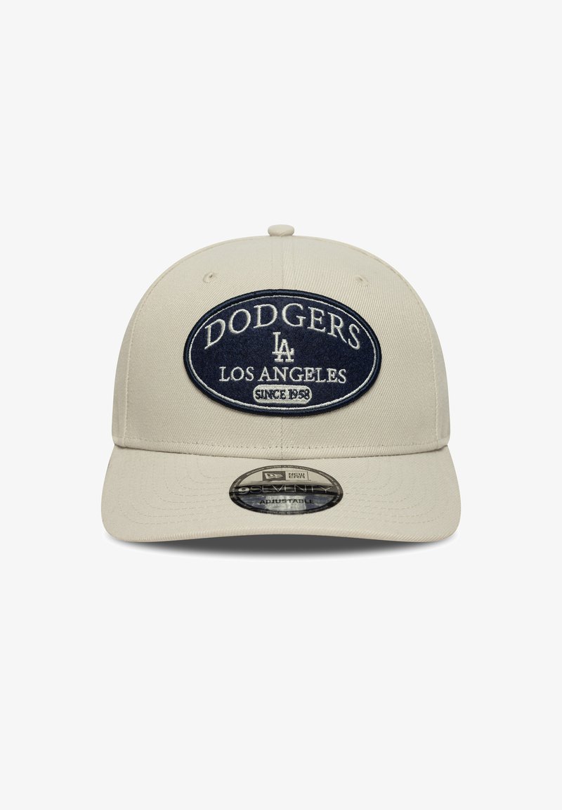 Beige Baseballmütze mit strukturierter Form. Verfügt über ein dunkelblaues ovales Patch mit "DODGERS LOS ANGELES" und "SINCE 1958" in weißer Stickerei.
