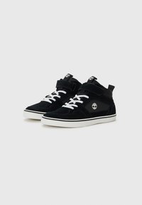 Black suede high-top sneakers with white laces, Velcro strap, and gray rubber sole. Features logo on side and padded collar for comfort.