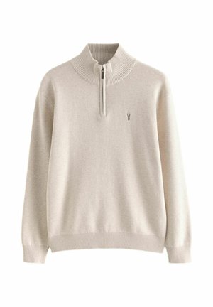 Beige højhalset pullover sweater med ribbet detaljering ved kraven og kanten, med en kvart lynlås og et lille logo på brystet.