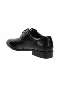 Zwartleren schoenen met een gepolijste afwerking, vetersluiting, ronde neus en een lage, stevige rubberen hak voor stabiliteit.