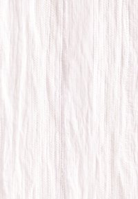 Tissu blanc avec différents motifs texturés verticaux, comprenant des côtes et des motifs tressés.