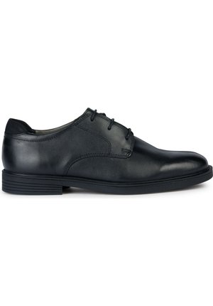 Chaussure habillée en cuir noir avec un bout arrondi, un design à lacets, une texture lisse et un petit talon en caoutchouc. Dotée de détails de couture subtils.