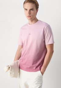 T-shirt dégradé rose, à manches courtes, col rond, avec un petit logo "BOSS" brodé sur la poitrine. Le tissu semble lisse et léger.