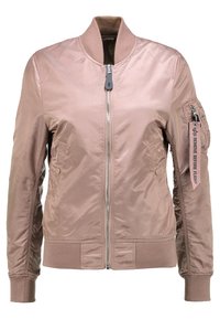 Ljusrosa bomberjacka i ett smidigt, skinande material. Har en framdragkedja, ribbade ärmslut och en ficka med en etikett som säger "TA BORT INNAN FLYGNING".