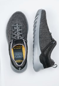 Grau gefütterte Sneakers mit schwarzen Akzenten, strukturierten Oberflächen und grauen Gummisohlen. Mit grauen Schnürsenkeln und einer gepolsterten Innensohle mit Branding.