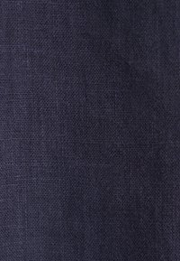 Tessuto in lino di un blu navy scuro con una trama testurizzata, che mostra un motivo sottile e uniforme e una leggera lucentezza. Distribuzione del colore uniforme in tutto il tessuto.