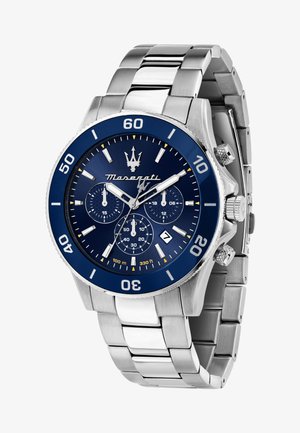 Montre chronographe en acier inoxydable avec une lunette et un cadran bleus, des accents argentés, trois sous-cadrans et affichage de la date à la position six heures.