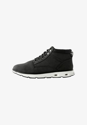 Black synthetic ankle boots with a smooth texture, white outsole featuring air pockets, and round metal eyelets for laces.