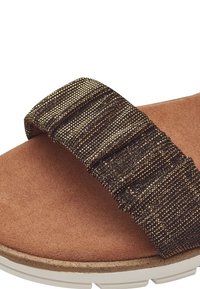 Hnědá nubuková stélka s tmavě metalickou tkanou páskou, která má texturovaný design. Silná podešev s kulatým tvarem.