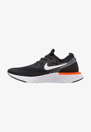 Chaussure de running Nike noire avec semelle blanche, logo swoosh blanc et accent orange près du talon, montrée en profil latéral sur fond blanc.