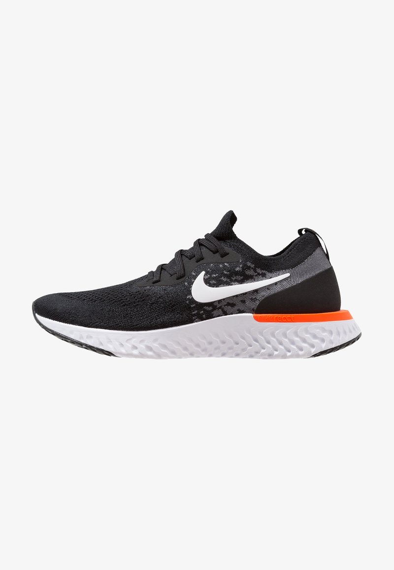 Chaussure de running Nike noire avec semelle blanche, logo swoosh blanc et accent orange près du talon, montrée en profil latéral sur fond blanc.