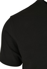 Fekete pamut póló, kerek nyakkivágással és rövid ujjal, sima textúrával és testhez álló fazonnal.