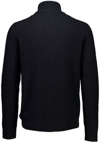 Svart stickad tröja med hög krage, ribbade ärmar och nederkant. Det texturerade mönstret påminner om en fiskbensdesign för extra detaljer.