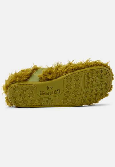 Fuzzy, olive green slip-on sandal with rubber sole featuring round grip patterns. Soft texture and a wide strap design for comfort.