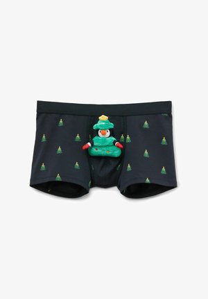 Calzoncillos boxer negros con patrón de árboles de Navidad verdes; cuentan con un pingüino de peluche vestido como un árbol de Navidad en la parte delantera.