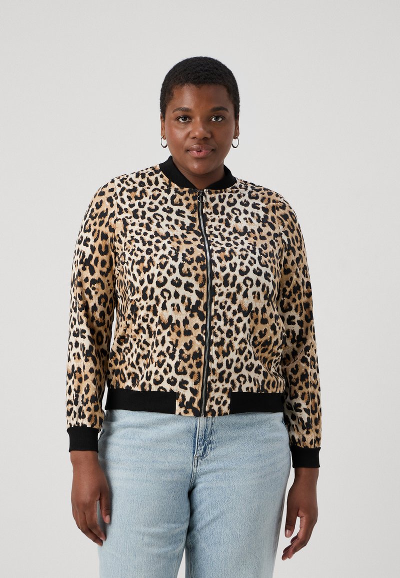 Leopard print bomber jacket with zip closure, black ribbed collar and cuffs, and a textured fabric. Worn over light wash jeans.