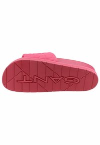 Pink rubber sandal with a textured, contoured sole. Features a padded strap with a quilted design and embossed brand name.