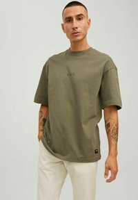 T-shirt oversize verde oliva in cotone con collo rotondo, maniche corte e logo stampato "R.D.D." sul petto. Texture morbida.