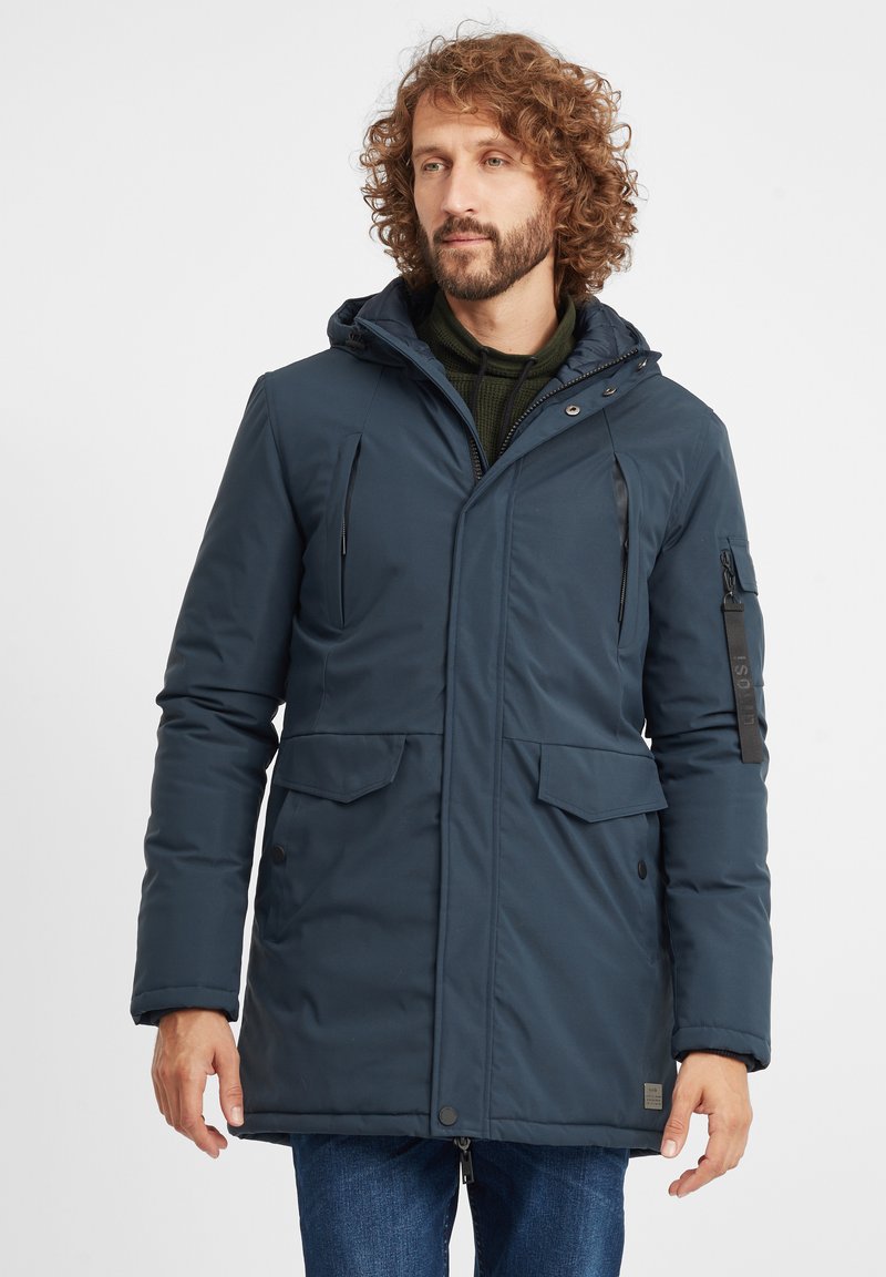 Mornarsko plavi insulated parka kaput s kapuljačom, zatvaračem sprijeda, dva prednja džepa i džepom na rukavu sa zatvaračem i logotipom.