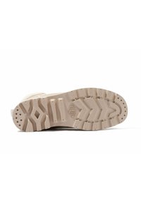 Suela de zapato de goma en tono marrón con un patrón texturizado que presenta surcos y hendiduras profundas para mayor tracción. Incluye agarres en forma circular y de diamante.