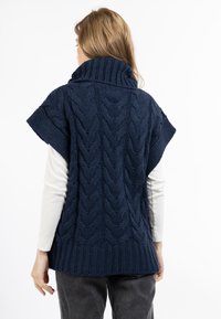 Mørkeblå kabelstrikket sweater med høj krave og korte ærmer, med ribbet kant og tekstur detaljer hele vejen igennem.