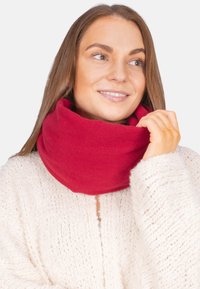 Roter, gestrickter Infinity-Schal aus weichem Material, mit einer glatten Textur und einem kontinuierlichen Loop-Design für Wärme und Komfort.