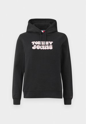 Sweatshirt preto feito de um tecido em mistura de algodão, apresentando um logo em texto rosa na parte da frente com a inscrição "TOMMY JEANS" em uma fonte arredondada. Capuz ajustável com cordão.