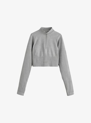 Suéter gris corto con media cremallera, mangas largas, textura acanalada y un discreto logo en la cintura. Acabado de tela suave.