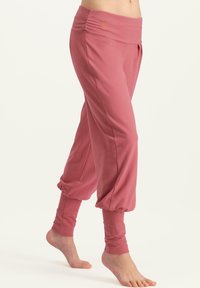 Rosa, weiche Stoffhose mit breitem Bund, schmal zulaufenden Abschlüssen und gefaltetem Design. Mit einem dezenten Logo am Bund.