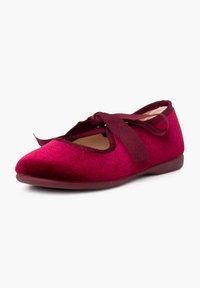 Ballerine en velours rouge avec des liens ruban croisés et un bout rond sur une semelle plate sur fond blanc.