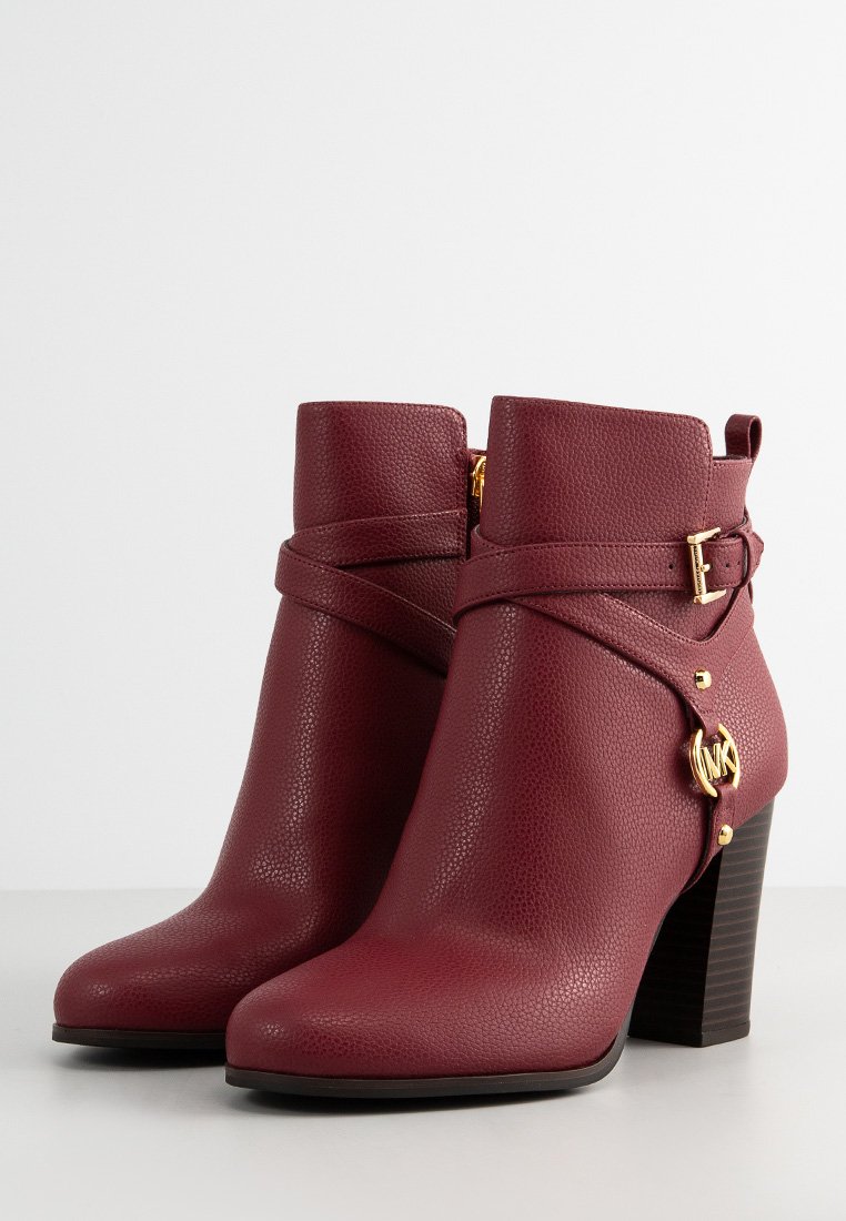 Stivaletti borgogna in pelle testurizzata, con fibbia e dettagli in metallo dorato, tacco a blocco e design con cinturini intrecciati.