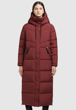 Duga, podstavljena jakna u burgundskom tonu s visokim ovratnikom i kapuljačom. Ima džepove na zatvarač i kontrastne crne detalje. Elegantan, ravni siluet.