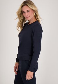 Navyblauwe sweatshirt in een aansluitend ontwerp, gemaakt van zacht materiaal met ribgebreide manchetten en taille, met een eenvoudige ronde halslijn.