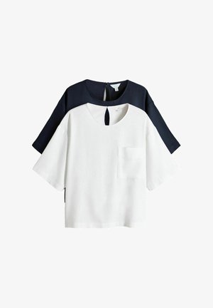 Két rövid ujjú blúz, az egyik fehér elülső zsebbel és kulcslyuk nyakkivágással, a másik fekete hasonló kulcslyuk részlettel, egymáson lefektetve.