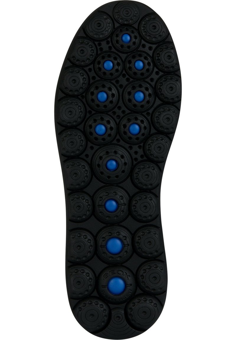 Suela de zapato de goma negra con patrones circulares y acentos azules. Incluye orificios de aire y superficies texturizadas variadas para mayor tracción.