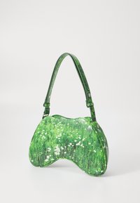 Sac à main en cuir vert présentant un motif herbeux avec des fleurs blanches, de forme courbée, et une bandoulière assortie avec des accents en métal.