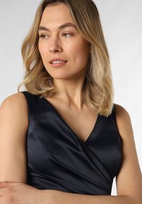 Navy Satin-Kleid mit V-Ausschnitt und Wickeldesign; zeichnet sich durch eine glatte Textur und ärmellosen Schnitt aus, der subtile Drapierung zur Schau stellt.