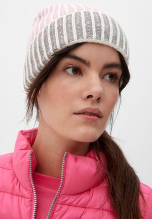 Strickmütze in rosa, grau und cremefarbenen Streifen mit umgeschlagenem Bündchen. Getragen mit einer leuchtend pinken, mit Reißverschluss versehenen Steppjacke. Glatte Textur.