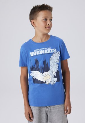 Blauwe katoenen t-shirt met een witte afbeelding van een uil die een brief vasthoudt, en de tekst "WACHTEND OP MIJN BRIEF VAN HOGWARTS" in vetgedrukte witte letters.