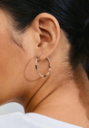 Gold-tone hoop earring featuring multi-colored beads in pink, black, and beige. The earring is slim with a textured surface.