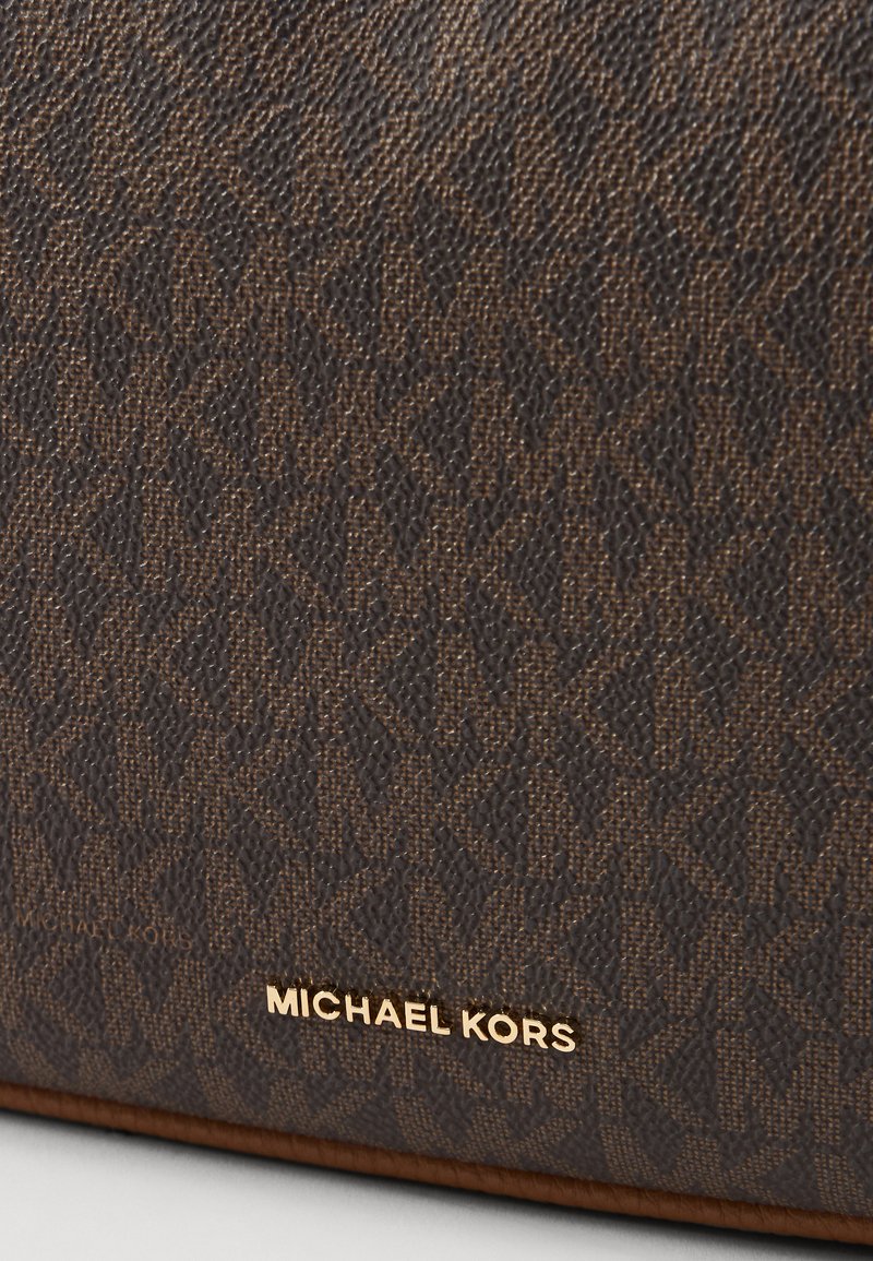 Borsa a tracolla marrone con texture, caratterizzata da un motivo logo e accenti dorati. Materiale liscio con un design strutturato.