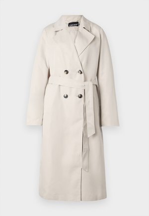 Gabardina beige con un frente de doble botón, amplio cuello y cintura ceñida con cinturón. Presenta mangas largas y un dobladillo recto.
