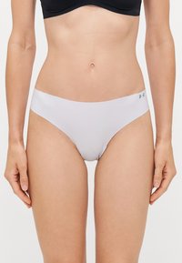 White bikini bottom made of smooth, stretch fabric featuring a low-rise design and subtle branding on the waistband.