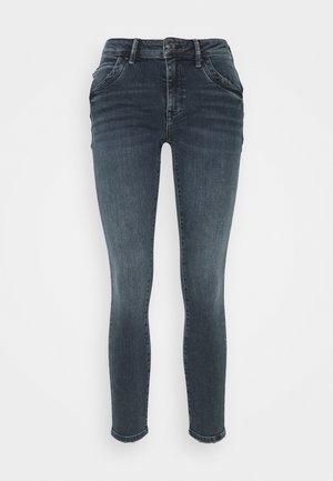 Mørkegrå slim-fit cowboybukser med forlommer, knaplukning og subtil falmning langs lårene og knæene, vist på en ensfarvet baggrund.