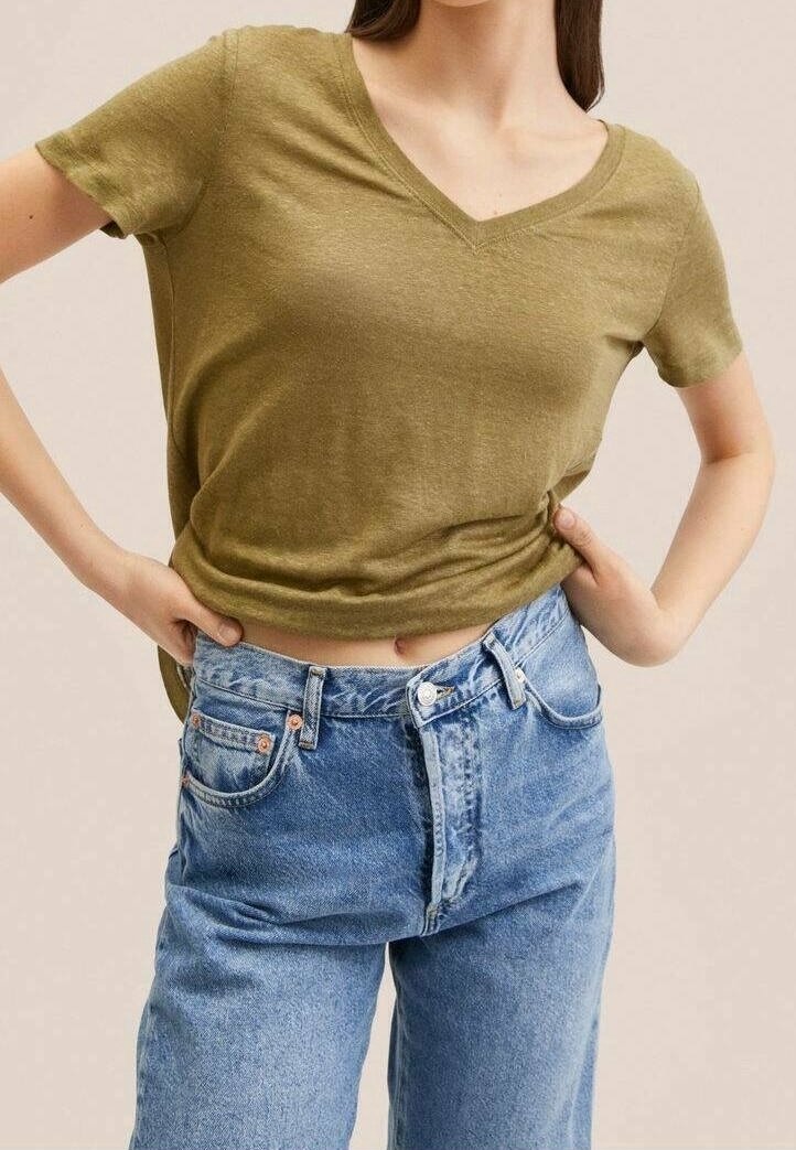 Olijfgroene, korte mouwen V-hals t-shirt gecombineerd met high-waisted, lichtblauwe, loszittende denim jeans; casual pasvorm en zachte textuur.