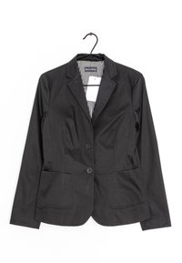 Blazer negro ajustado con dos botones, dos bolsillos frontales, solapas muesca y forro a rayas, colgado en una percha negra.