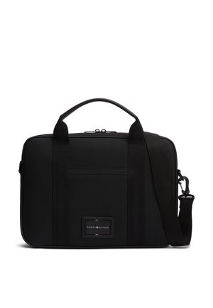 Czarna prostokątna teczka z górnym uchwytem i regulowanym paskiem na ramię, z naszywką z logo na przodzie i poziomym zamkiem kieszeni z przodu.